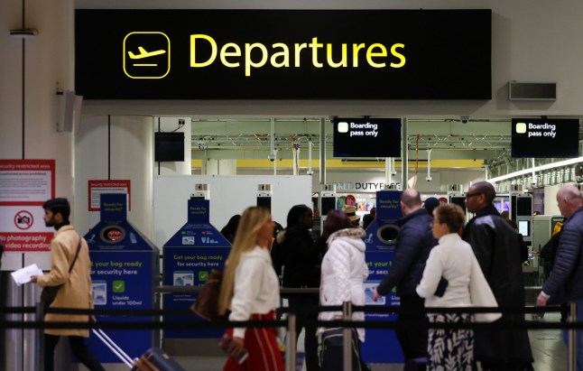 Passengers queue at airport departure at Gatwick.
