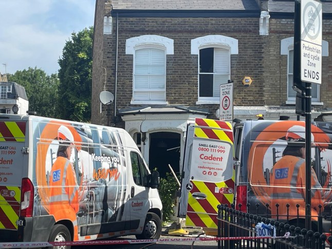Cadent gas network vans are seen parked outside of the house in Dumont Road
